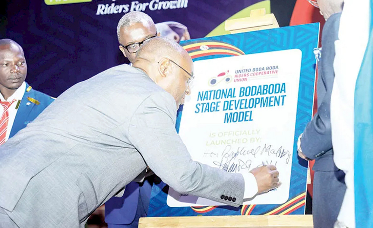 Local Government minister Raphael Magyezi signs pledge board during the launch of the United Boda Boda Stage Development Model at Kampala Serena hotel. Photo Credit: https://observer.ug/business/boda-boda-riders-initiative-seeks-to-establish-own-bank/
